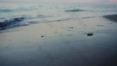 晚上海滨关闭特写镜头平静海洋水波溅桑迪海滩